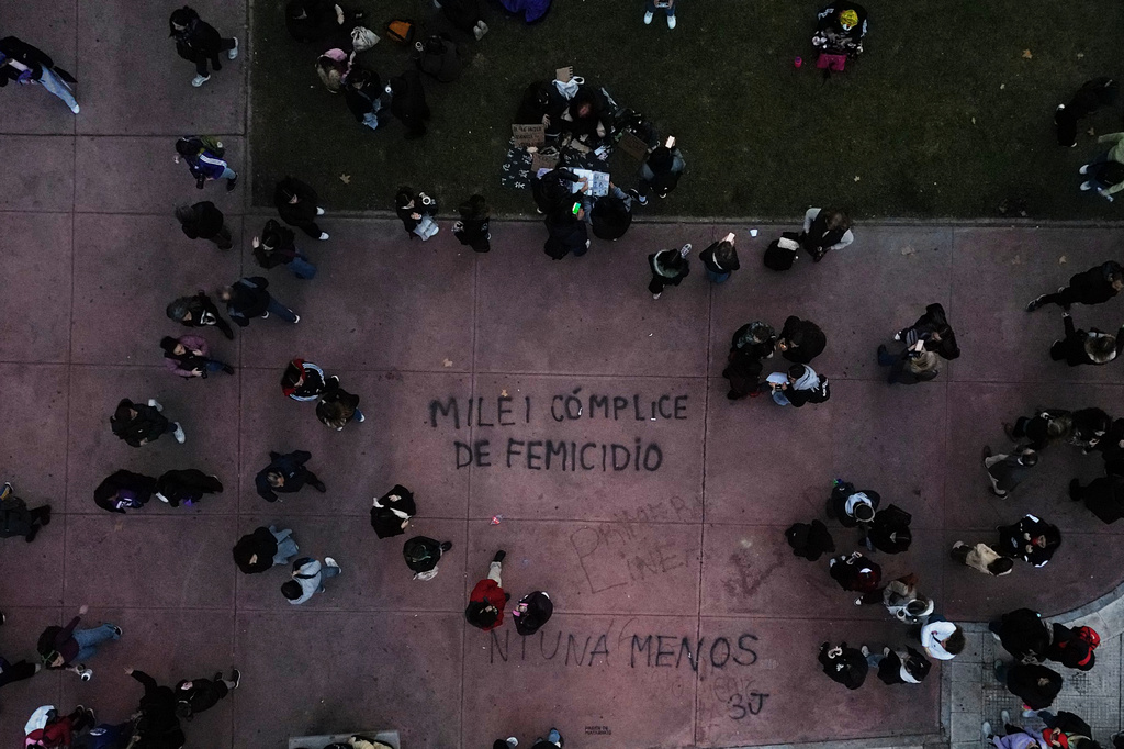 Demontrators walk near a painting reading in Spanish " Milei femicide accomplice" referring to President Javier Milei during a march marking the anniversary of the "Ni Una Menos" (Not One Fewer) women's movement in Buenos Aires, Argentina, Wednesday, June 3, 2026. (AP Photo/Natacha Pisarenko)