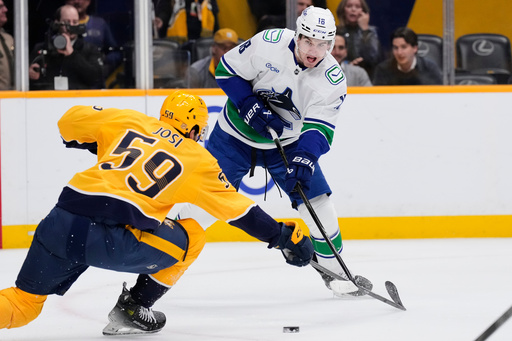 Vancouver Canucks left wing Drew O'Connor (18) shoots the puck past Nashville Predators defenseman Roman Josi (59) during the first period of an NHL hockey game Thursday, Oct. 23, 2025, in Nashville, Tenn. (AP Photo/George Walker IV) Vancouver Canucks left wing Drew O'Connor (18) shoots the puck past Nashville Predators defenseman Roman Josi (59) during the first period of an NHL hockey game Thursday, Oct. 23, 2025, in Nashville, Tenn. (AP Photo/George Walker IV)