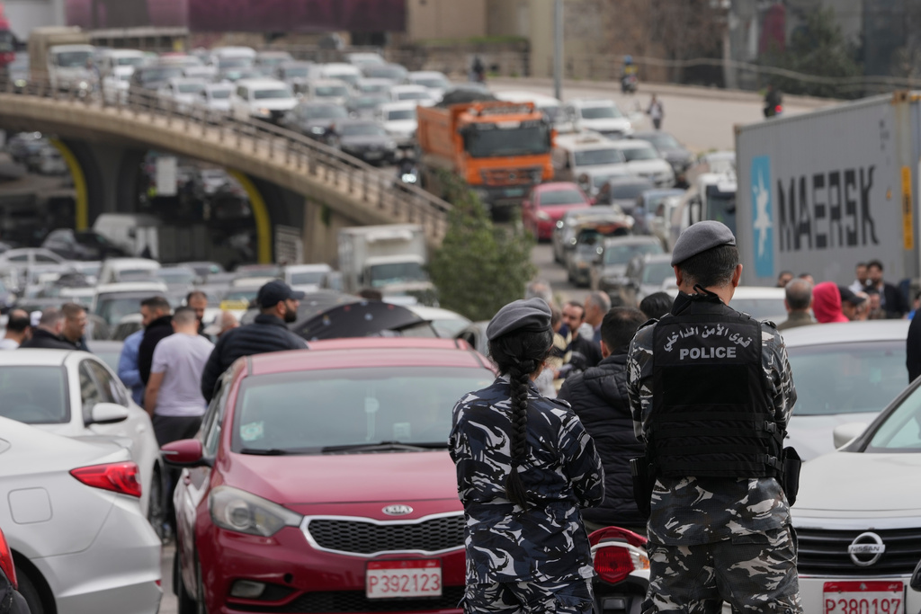 Lebanese police stand in front of taxi drivers who block a main highway with their cars during a protest against the increased taxes and gasoline prices issued by the Lebanese Cabinet on Monday, in Beirut, Lebanon, Tuesday, Feb. 17, 2026. (AP Photo/Hussein Malla)