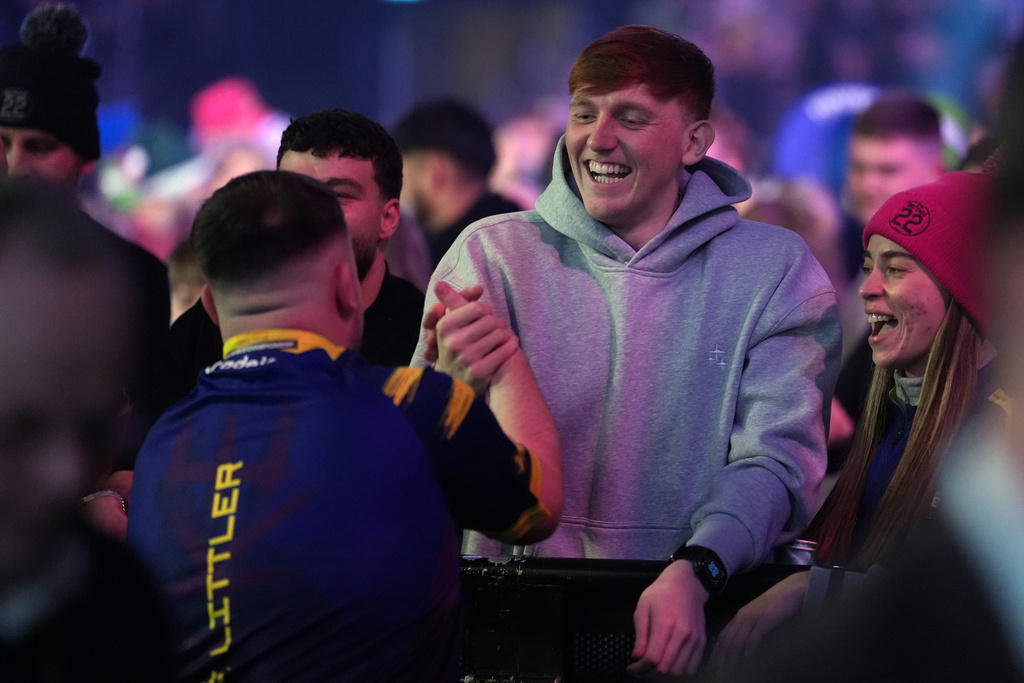 England's Luke Littler shakes hands with You Tuber Angryginge after winning the World Darts Championships semifinal match against England's Ryan Searle at Alexandra Palace in London, Friday, Jan. 2, 2026.(AP Photo/Dave Shopland)