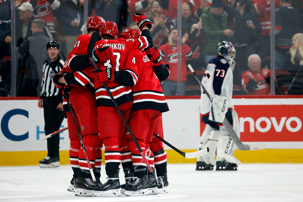 The Carolina Hurricanes celebrate a goal by Jordan Staal (11) as Columbus Blue Jackets goaltender Jet Greaves (73) skates back to the net during the third period of an NHL hockey game in Raleigh, N.C., Tuesday, Dec. 9, 2025. (AP Photo/Karl DeBlaker)