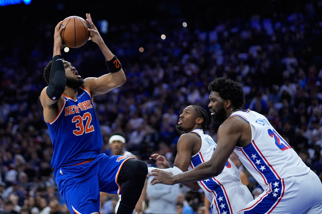 New York Knicks' Karl-Anthony Towns, from left, goes up for a shot against Philadelphia 76ers' Tyrese Maxey, and Joel Embiid during the first half of Game 4 in a second-round NBA basketball playoffs series Sunday, May 10, 2026, in Philadelphia. (AP Photo/Matt Slocum)