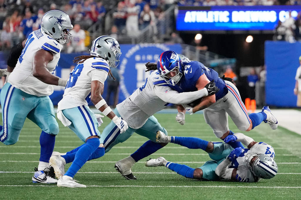 New York Giants running back Cam Skattebo (44) is brought down by a host of Dallas Cowboys defenders during the second half of an NFL football game Sunday, Sept. 13, 2026, in East Rutherford, N.J. (AP Photo/Yuki Iwamura)