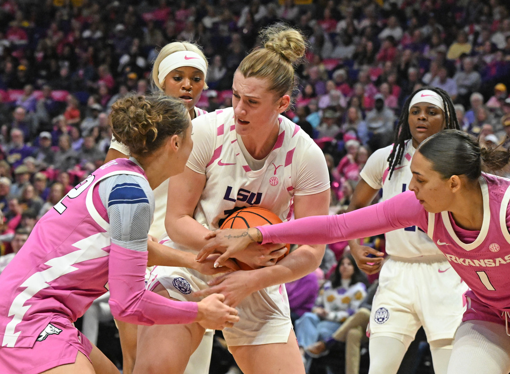 LSU forward Kate Koval, center, fights for control of the ball against Arkansas guard Bonnie Deas (22) and Arkansas forward Maria Anais Rodriguez (1) during an NCAA college basketball game Thursday, Jan. 29, 2026, in Baton Rouge, La. (Hilary Scheinuk/The Advocate via AP)