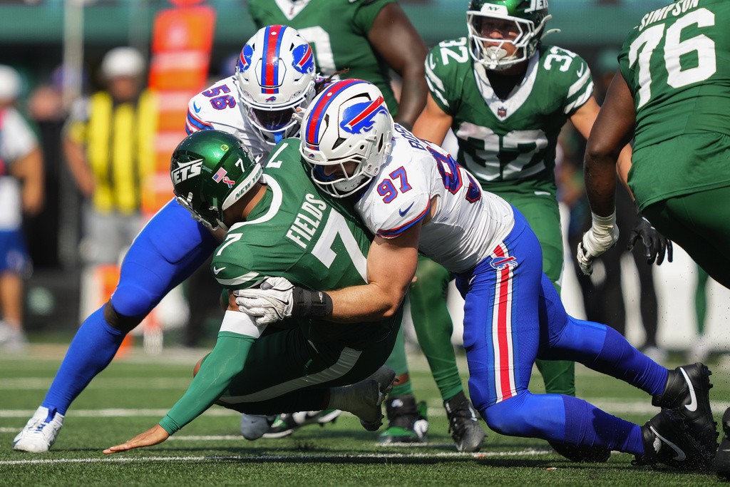 New York Jets quarterback Justin Fields (7) is sacked by Buffalo Bills defensive end Joey Bosa (97) and defensive end Javon Solomon (56) during the fourth quarter of an NFL football game, Sunday, Sept. 14, 2025, in East Rutherford, N.J. (AP Photo/Yuki Iwamura)
