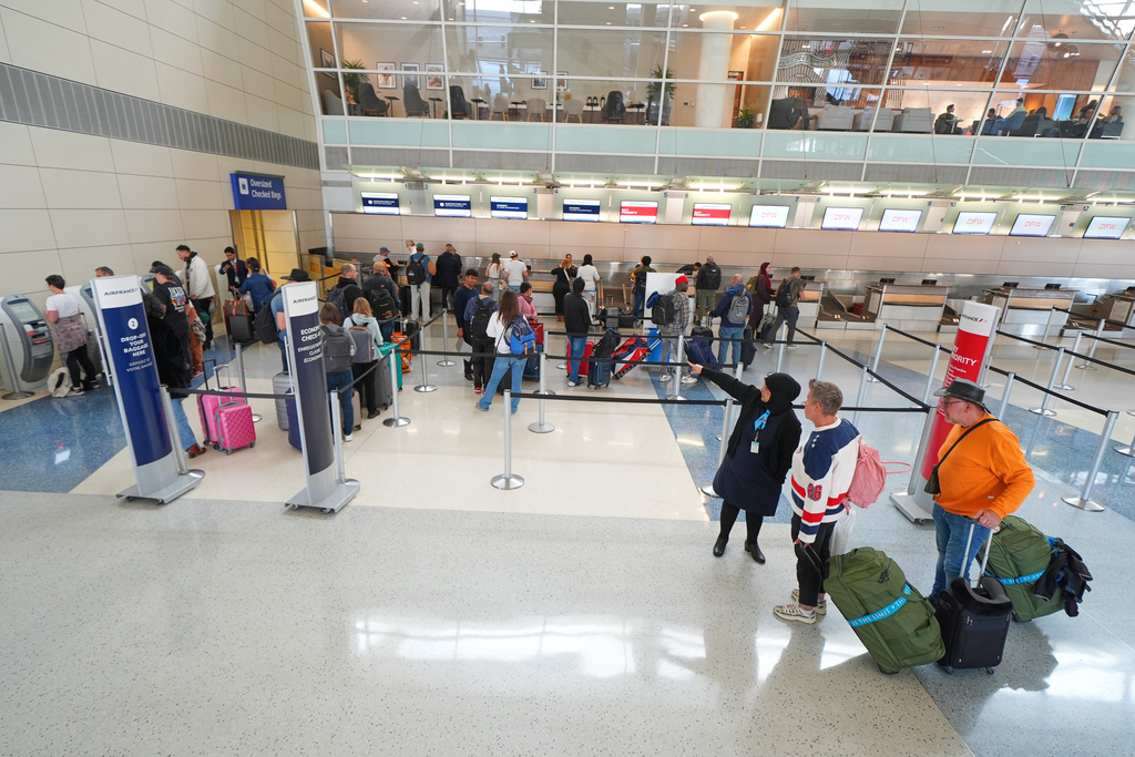 Travelers check in for flights at Terminal D of Dallas Forth Worth International Airport Friday, Nov. 7, 2025, in Grapevine, Texas. (AP Photo/Julio Cortez)