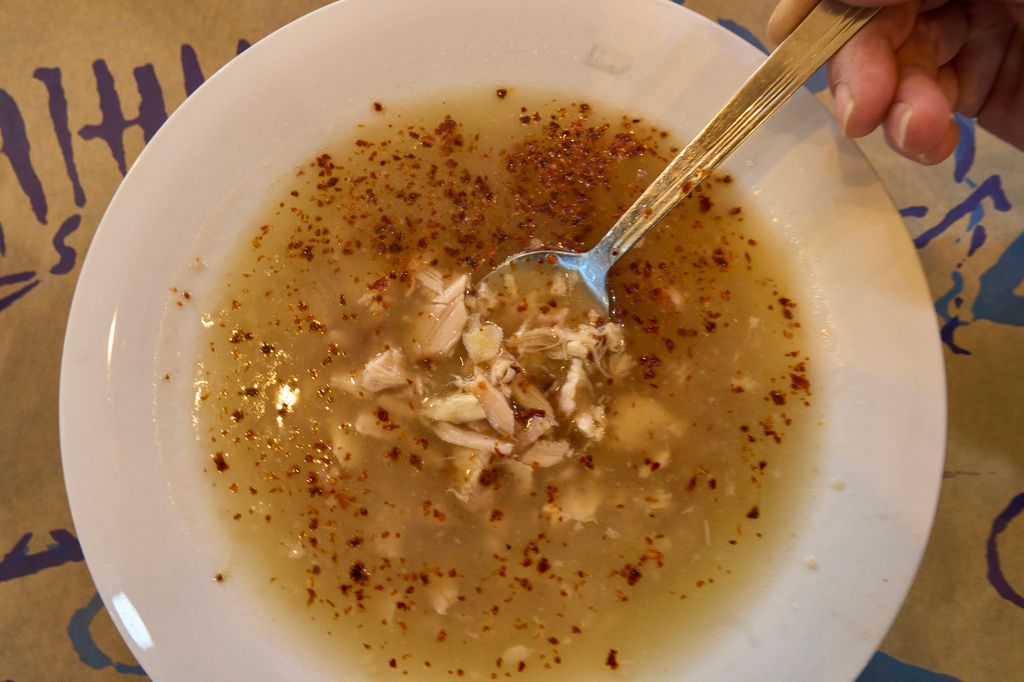A woman prepares to eat traditional tripe soup known as "patsas" in Greek and "iskembe" in Turkish, at Epirus restaurant in central Athens, on Friday, April 3, 2026. (AP Photo/Petros Giannakouris)