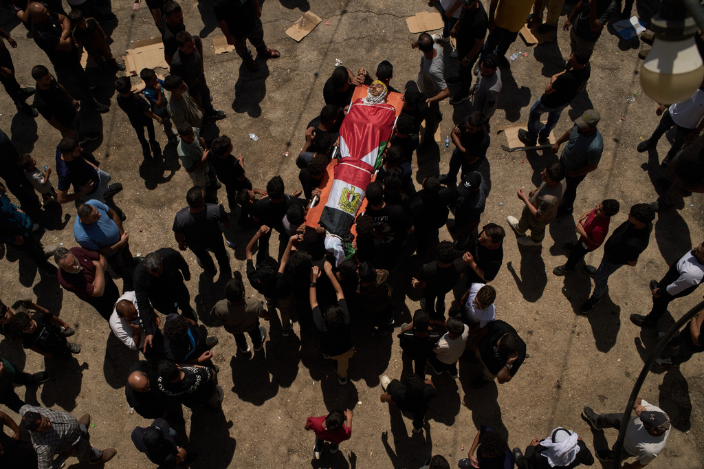 Palestinians carry the body of Omar Naasan, 19, who was killed by Israeli forces that were accompanying Israeli settlers the night before, during his funeral in the West Bank village of al-Mughayyir, Thursday, Sept. 3, 2026. (AP Photo/Leo Correa)