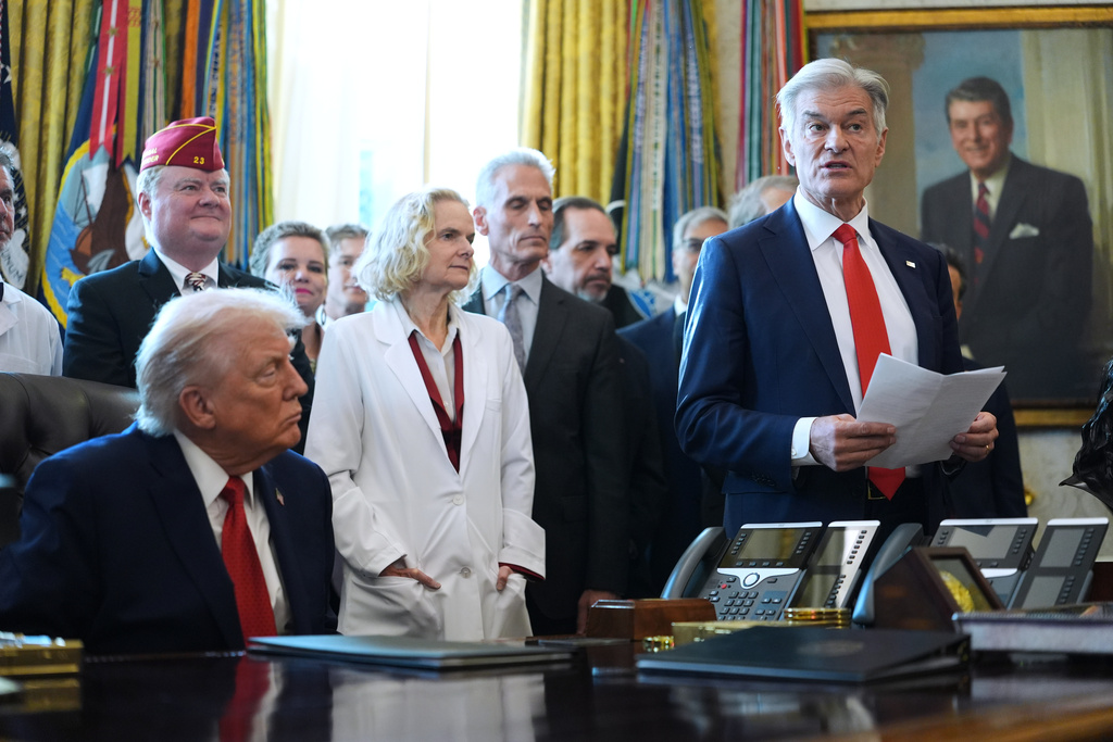 President Donald Trump listens as Centers for Medicare & Medicaid Services administrator Dr. Mehmet Oz speaks during an executive order signing in the Oval Office of the White House, Thursday, Dec. 18, 2025, in Washington. (AP Photo/Evan Vucci)