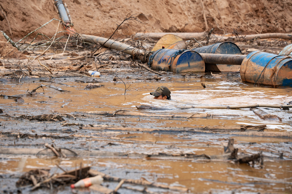 A Peruvian Navy soldier swims in a human-made pool to extract gold using chemical products during an operation to combat illegal mining in the Tambopata National Reserve in Puerto Maldonado, Peru, Tuesday, Aug. 11, 2026. (AP Photo/Guadalupe Pardo)