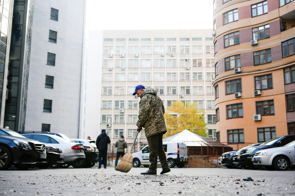 Bohdan Romaniv, 80, sweeps debris outside an apartment building that Russian attacks damaged, Wednesday, Oct. 22, 2025, in Kyiv, Ukraine. (AP Photo/Julia Demaree Nikhinson)