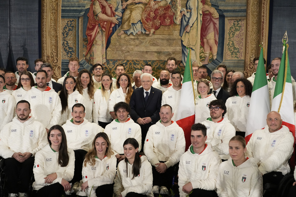 Italian President Sergio Mattarella, center, poses for a group photo with Olympic and Paralympic athletes during the hand over ceremony of the Italian flag for the Milan-Cortina Winter Olympic games, at the Quirinale Presidential palace, in Rome, Monday, Dec. 22, 2025. (AP Photo/Gregorio Borgia)