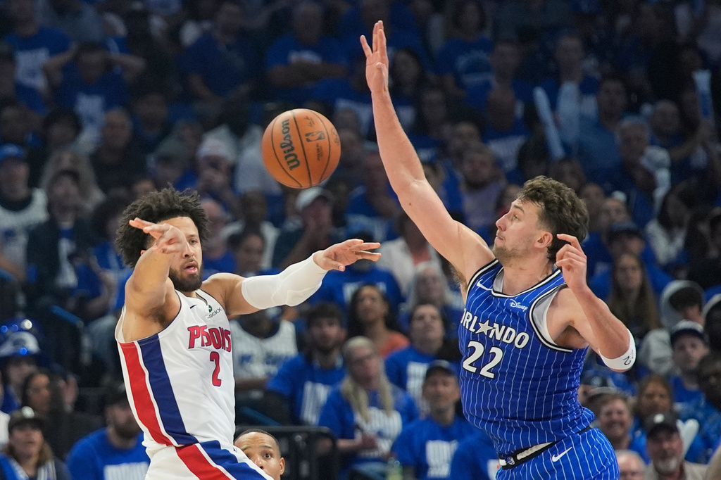Detroit Pistons guard Cade Cunningham (2) passes the ball past Orlando Magic forward Franz Wagner (22) during the second half in Game 4 of a first-round NBA basketball playoff series, Monday, April 27, 2026, in Orlando, Fla. (AP Photo/John Raoux)