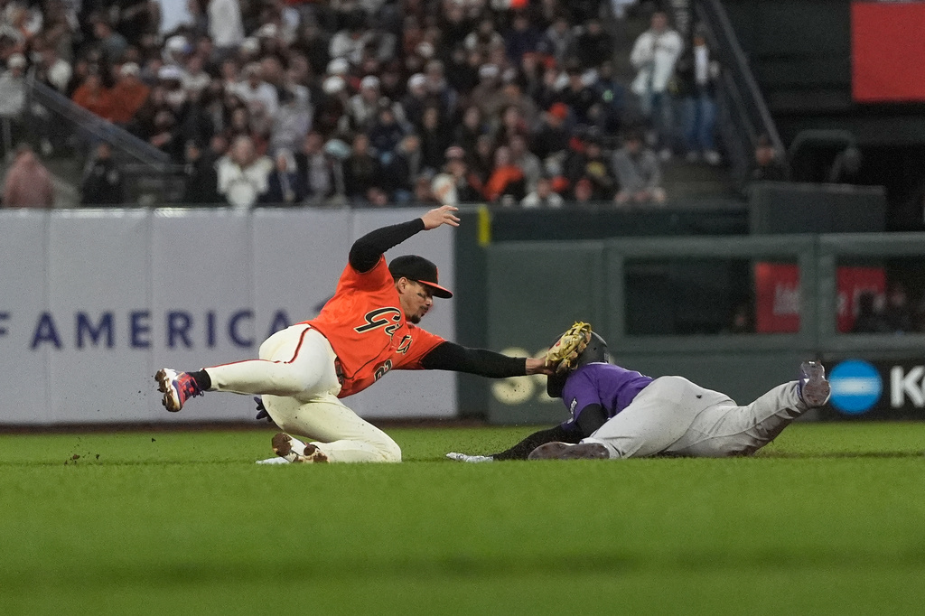 Colorado Rockies' Hunter Goodman, right, is tagged out by San Francisco Giants shortstop Willy Adames while trying to steal second base during the fourth inning of a baseball game, Friday, July 10, 2026, in San Francisco. (AP Photo/Jeff Chiu)