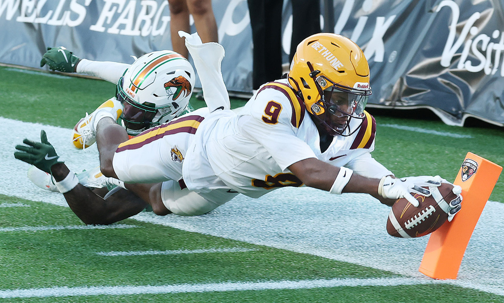 BCU wide receiver Maleek Huggins (9) reaches into the endzone for a touchdown in the grasp of FAMU defensive back Ah'Mare Lee (19) during an NCAA college football game of Bethune-Cookman versus Florida A&M in Orlando, Fla. on Saturday, Nov. 22, 2025. (Stephen M. Dowell/Orlando Sentinel via AP)