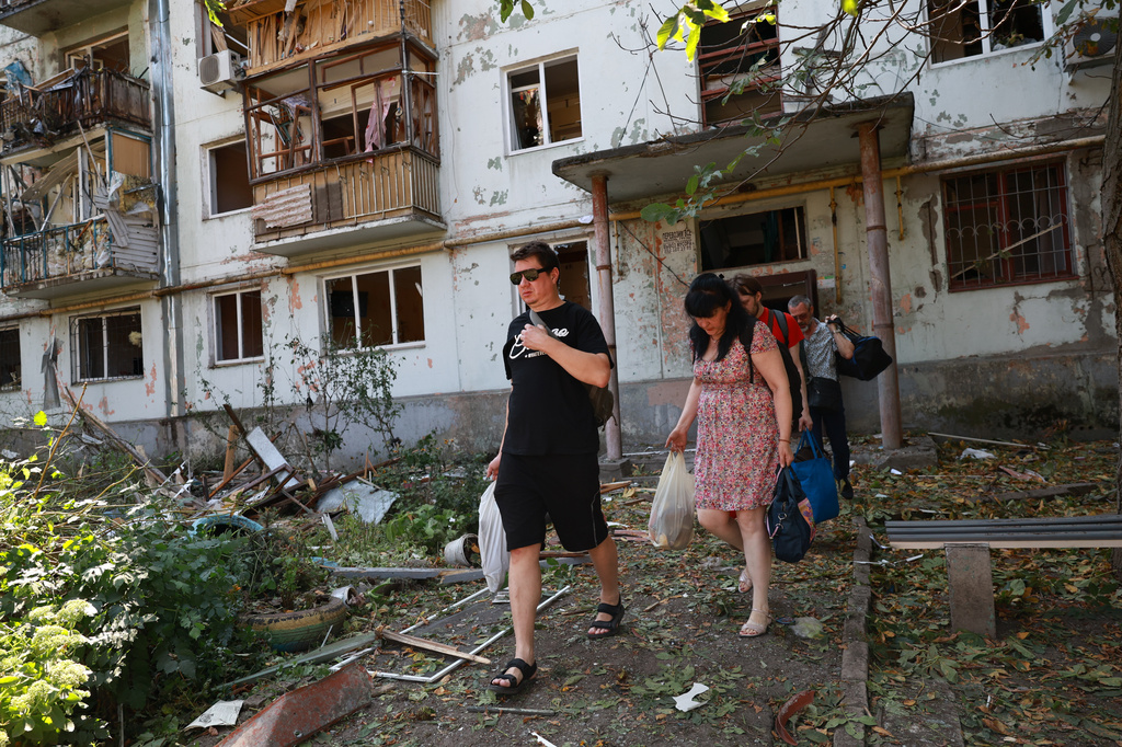 Residents leave their damaged home after a Russian air guided bomb strike in Zaporizhzhia, Ukraine, Monday, Aug. 10, 2026. (AP Photo/Kateryna Klochko)