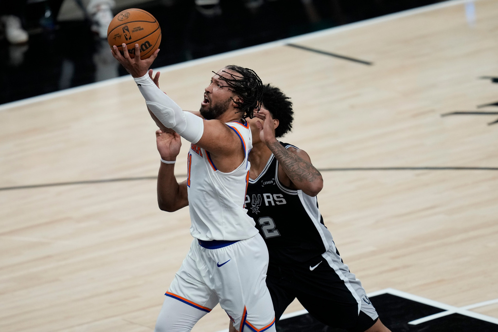 New York Knicks guard Jalen Brunson shoots past San Antonio Spurs guard Dylan Harper (2) during the first half of Game 1 of the NBA Finals basketball series, Wednesday, June 3, 2026, in San Antonio. (AP Photo/David J. Phillip)