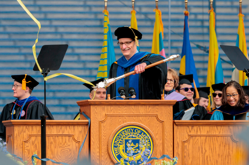 Derek Peterson, chair of the University of Michigan Faculty Senate, frees the ceremonial mace from falling ribbons during the University of Michigan's spring commencement ceremony at Michigan Stadium in Ann Arbor, Mich., Saturday, May 2, 2026. (Jacob Hamilton/Ann Arbor News via AP)