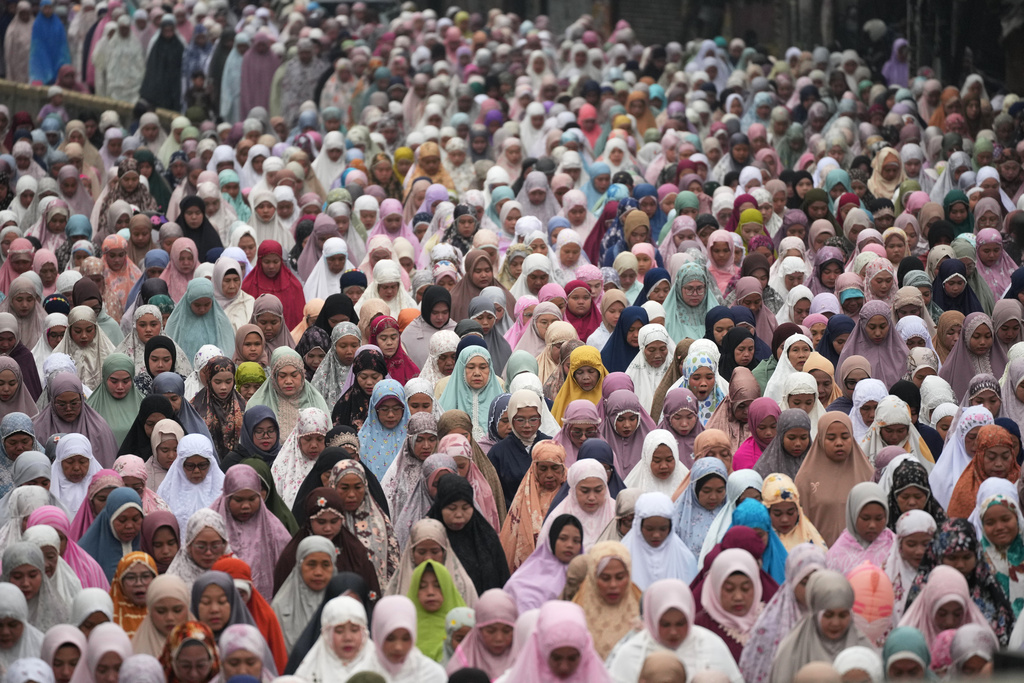 Women perform an Eid al-Fitr prayer marking the end of the holy fasting month of Ramadan on a street in Jakarta, Indonesia, Saturday, March. 21, 2026. (AP Photo/Tatan Syuflana)