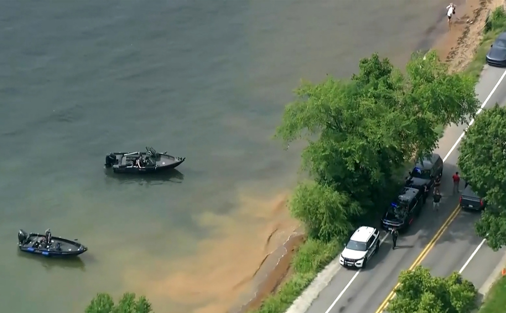 This image made from video provided by WISN-TV shows law enforcement use search boats in Geneva Lake, Wis., after receiving calls of an overturned boat on Friday, July 3, 2026. (WISN-TV via AP)