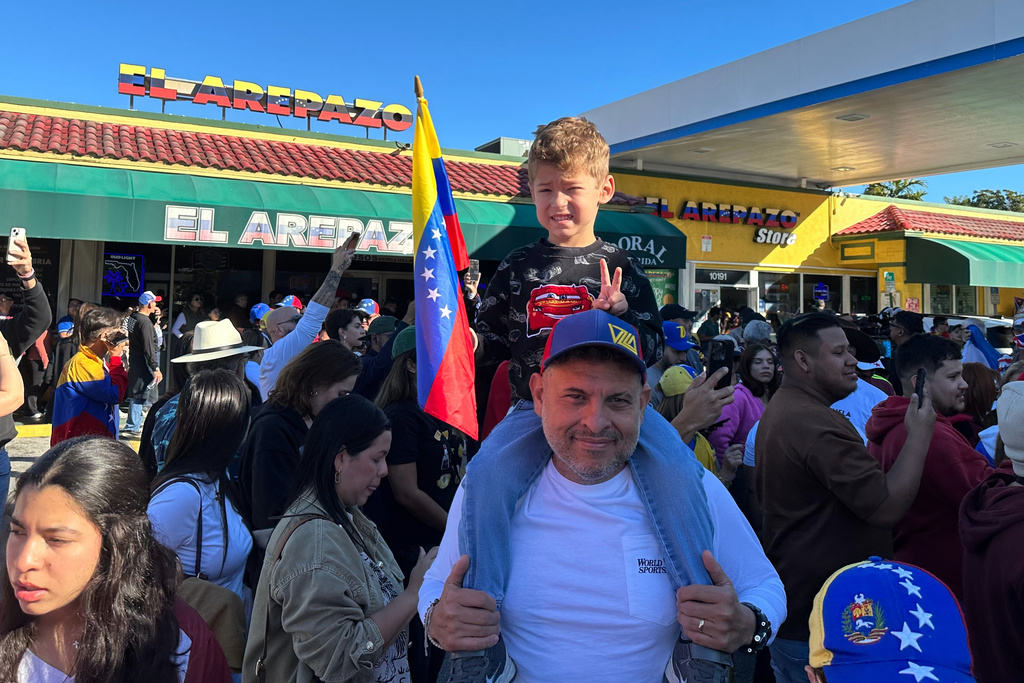 Lorenzo Coppola, 47, and his son Valentino join others to celebrate the news of Venezuelan President Nicolás Maduro capture in Doral, Fla., on Saturday, Jan. 3, 2026. (AP Photo/Vanessa Alvarez)