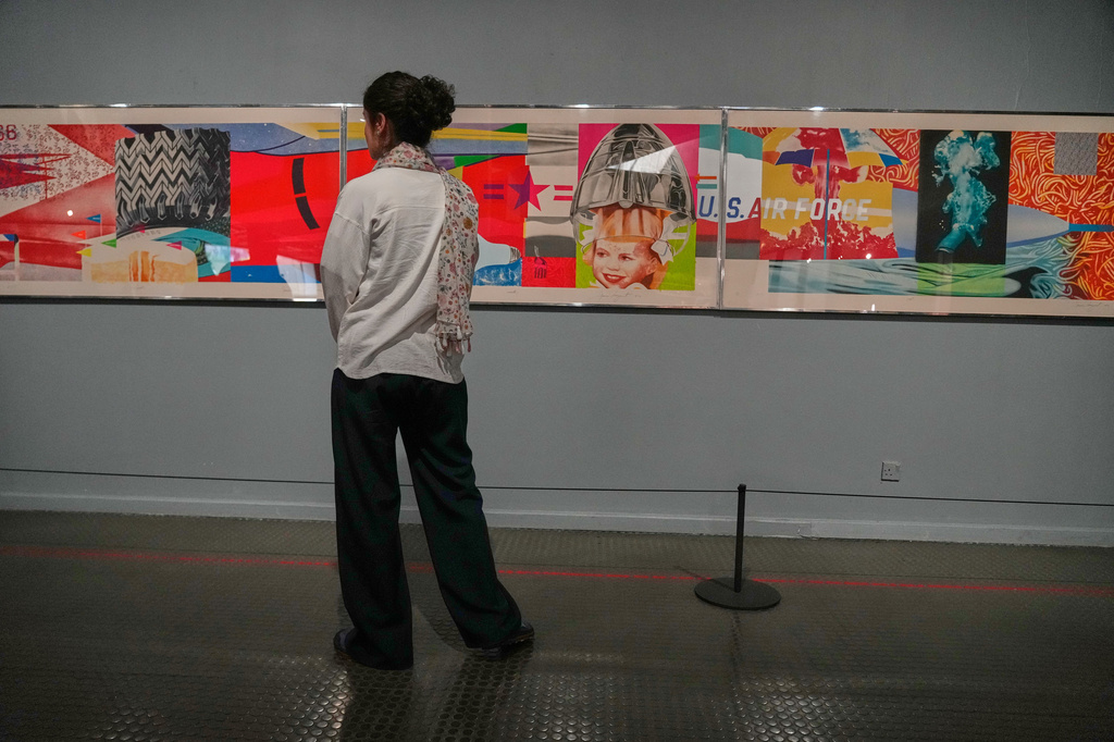 A woman looks at "F-111" an artwork of American artist James Rosenquist as she visits an exhibition called: "Art & war" displaying some artworks of American pop artists at the Tehran Museum of Contemporary Art in Iran, Thursday, May 7, 2026. (AP Photo/Vahid Salemi)