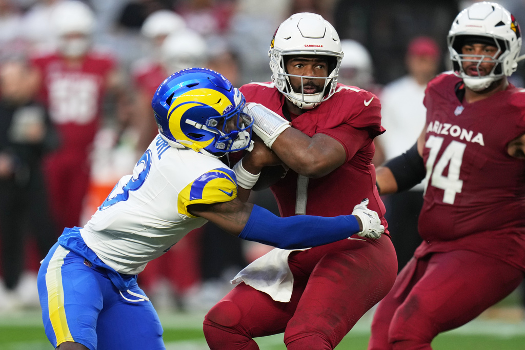 Los Angeles Rams safety Kam Curl, left, sacks Arizona Cardinals quarterback Jacoby Brissett, center, in the second half of an NFL football game Sunday, Dec. 7, 2025, in Glendale, Ariz. (AP Photo/Rick Scuteri)