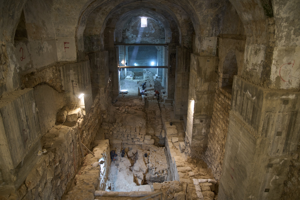 Workers from the Israel Antiquities Authority clean a section of an excavation site where, according to the institution, a city wall from the Hasmonean period, dating to the late 2nd century BCE, was uncovered under the Tower of David Citadel Museum, in the Old City of Jerusalem, Monday, Dec. 8, 2025. (AP Photo/Leo Correa)