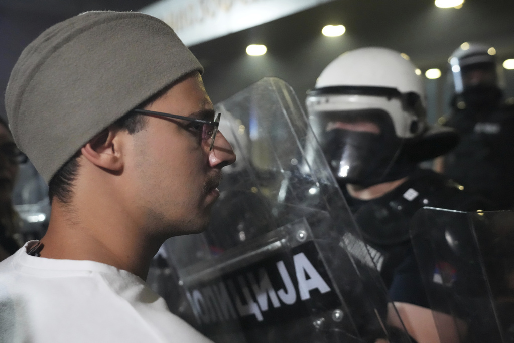 A man wearing a traditional Serbian hat stands in front of riot police cordon during a protest against increasing police brutality in the northern Serbian city of Novi Sad, Friday, Sept. 5, 2025. (AP Photo/Darko Vojinovic)
