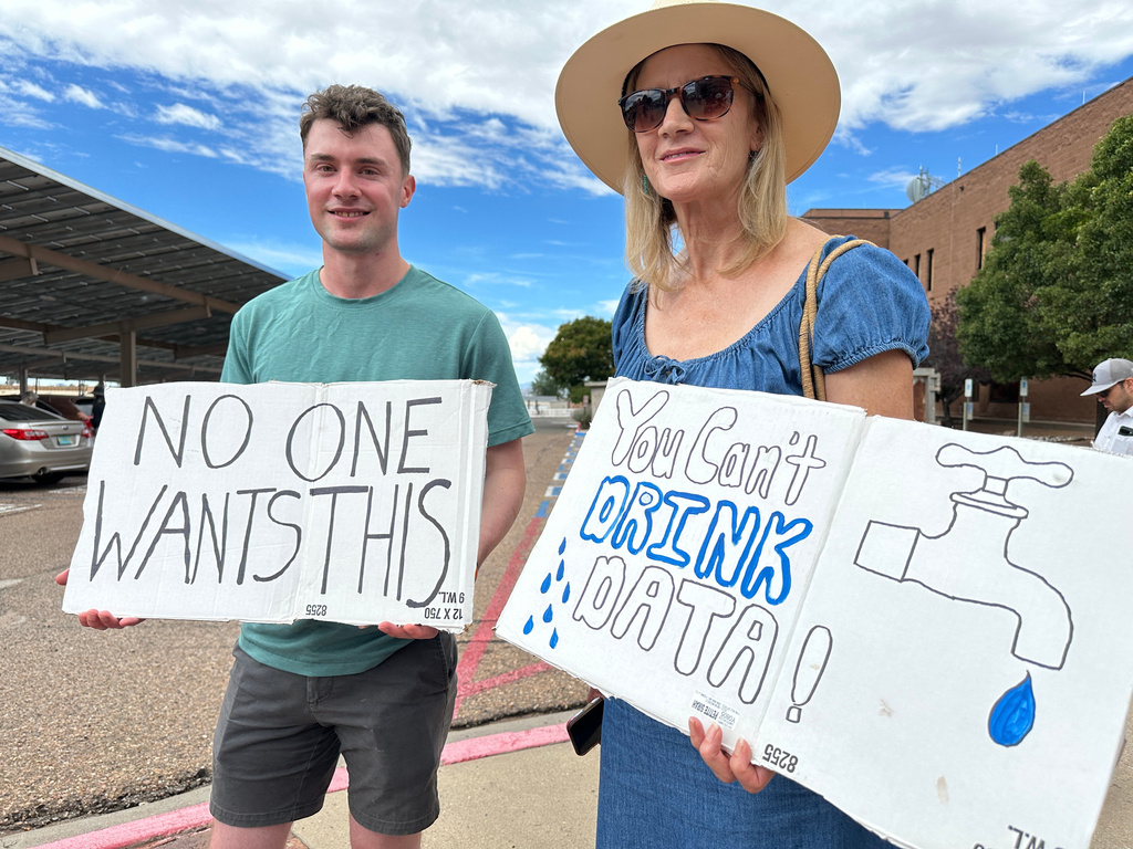 Jacob Weinreich and his mother Sharon Metcalf protest the Project Jupiter data center during a demonstration in Santa Fe, N.M., Friday, Aug. 21, 2026. (AP Photo/Susan Montoya Bryan)