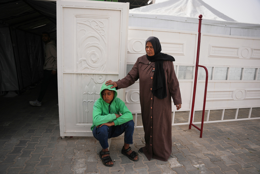Palestinian patient Mohammed Abu Mustafa, 17, accompanied by his mother, Randa, waits to board a bus in Khan Younis before they head to the Rafah crossing, leaving the Gaza Strip for medical treatment abroad, Monday, Feb. 2, 2026. (AP Photo/Abdel Kareem Hana)