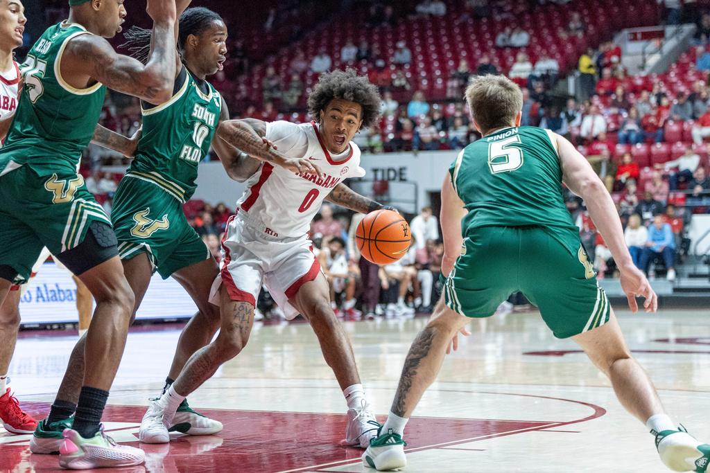 Alabama guard Labaron Philon Jr. (0) works against South Florida forward Tristan Beckford, second from right, during the first half of an NCAA college basketball game, Wednesday, Dec. 17, 2025, in Tuscaloosa, Ala. (AP Photo/Vasha Hunt)