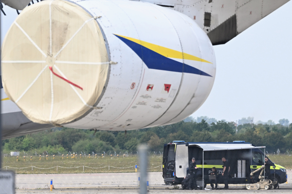 Police forensic technicians prepare to deploy an explosive-disposal robot near a Ukrainian aircraft at Leipzig/Halle Airport, in Schkeuditz, Germany, Wednesday Aug. 5, 2026, where flight operations were suspended overnight after a drone sighting was reported and another object was found near a runway. (Hendrik Schmidt/dpa via AP)