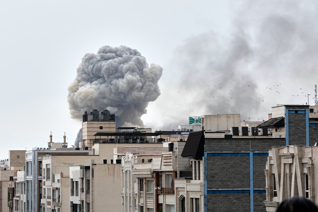 A plume of smoke rises after a strike in Tehran, Iran, Monday, March 2, 2026. (AP Photo/Vahid Salemi)