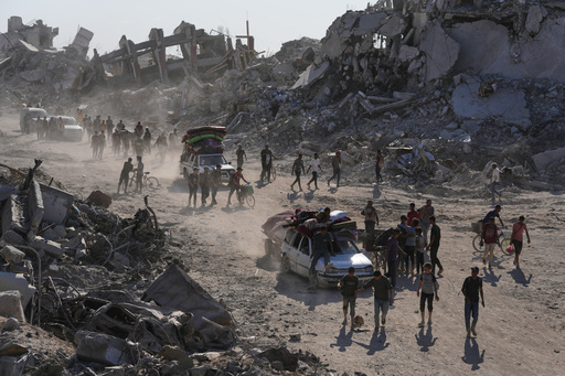 Displaced Palestinians with their belongings pass by destroyed buildings as they return to their homes in the Zeitoun neighborhood of Gaza City, Friday, Oct. 10, 2025, after Israel and Hamas agreed to pause their war and release remaining hostages. (AP Photo/Jehad Alshrafi) Displaced Palestinians with their belongings pass by destroyed buildings as they return to their homes in the Zeitoun neighborhood of Gaza City, Friday, Oct. 10, 2025, after Israel and Hamas agreed to pause their war and release remaining hostages. (AP Photo/Jehad Alshrafi)
