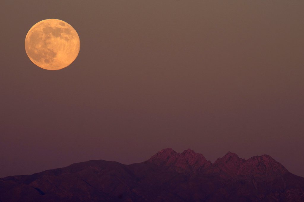The supermoon rises over the Superstition Mountains, Thursday, Dec. 4, 2025, in Phoenix. (AP Photo/Ross D. Franklin)