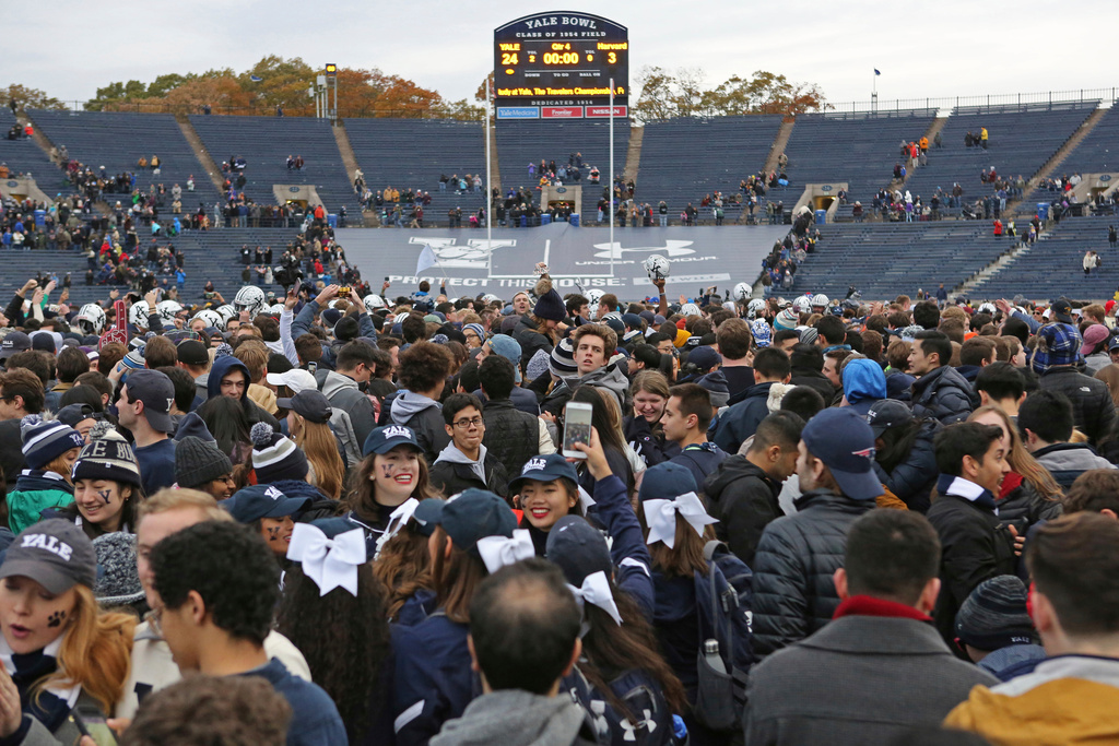 FILE - In this Nov. 18, 2017, file photo, Yale students rush the field after Yale defeated Harvard in an NCAA college football game in New Haven, Conn. (AP Photo/Gregory Payan, File)