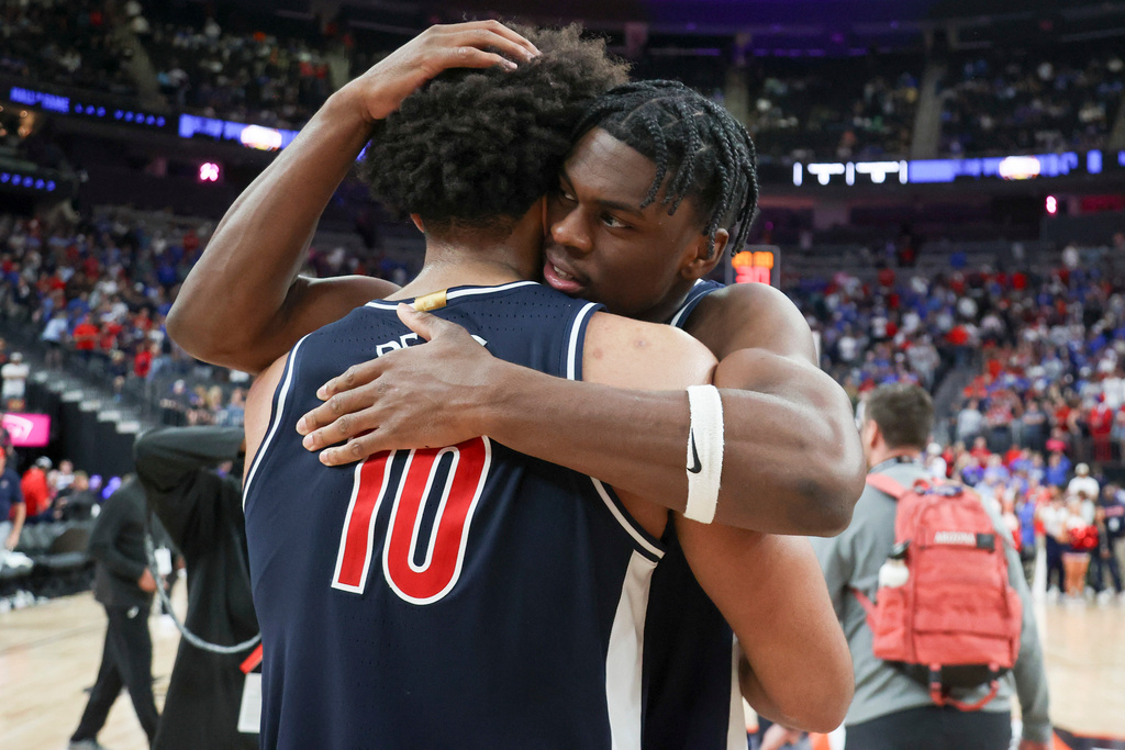 Arizona forward Dwayne Aristode (2) and Koa Peat (10) hug after their team's win against the Florida during an NCAA college basketball game, Monday, Nov. 3, 2025, in Las Vegas. (AP Photo/Ian Maule)