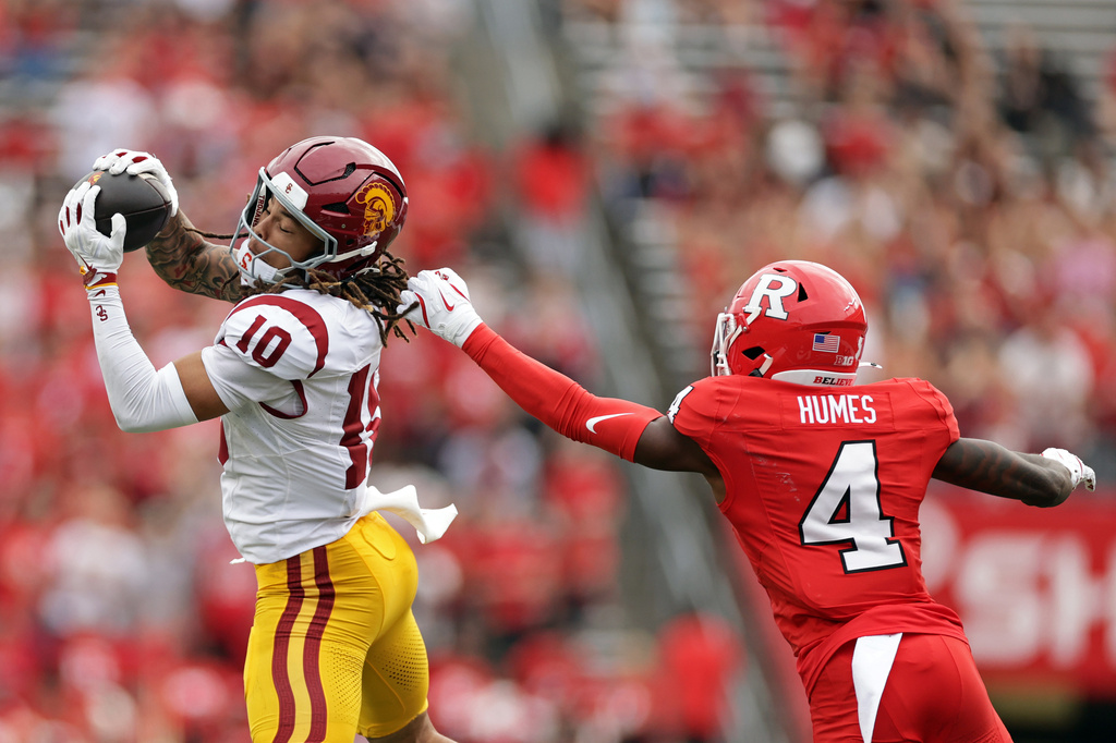 Southern California wide receiver Corey Simms (10) makes a catch in front of Rutgers defensive back Kevyn Humes (4) and runs for a touchdown during the first half of an NCAA college football game Saturday, Sept. 19, 2026, in Piscataway, N.J. (AP Photo/Adam Hunger)