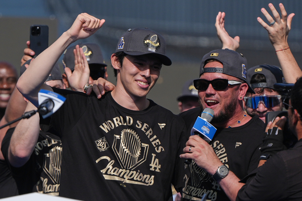 Los Angeles Dodgers' Miguel Rojas and Roki Sasaki smile during a celebration of the baseball team's World Series win at Dodger Stadium on Monday, Nov. 3, 2025, in Los Angeles. (AP Photo/Gregory Bull)