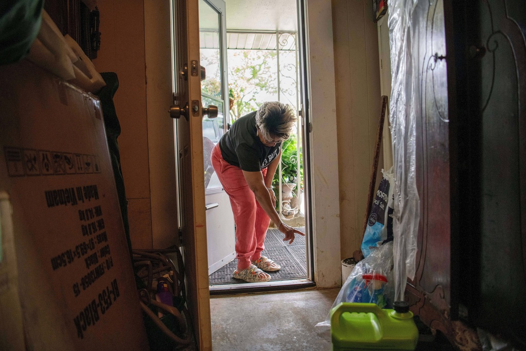 Yvette Lyles points to the spot on her wall reached by floodwaters in Cahokia Heights, Ill., May 15, 2025. (AP Photo/Michael Phillis)