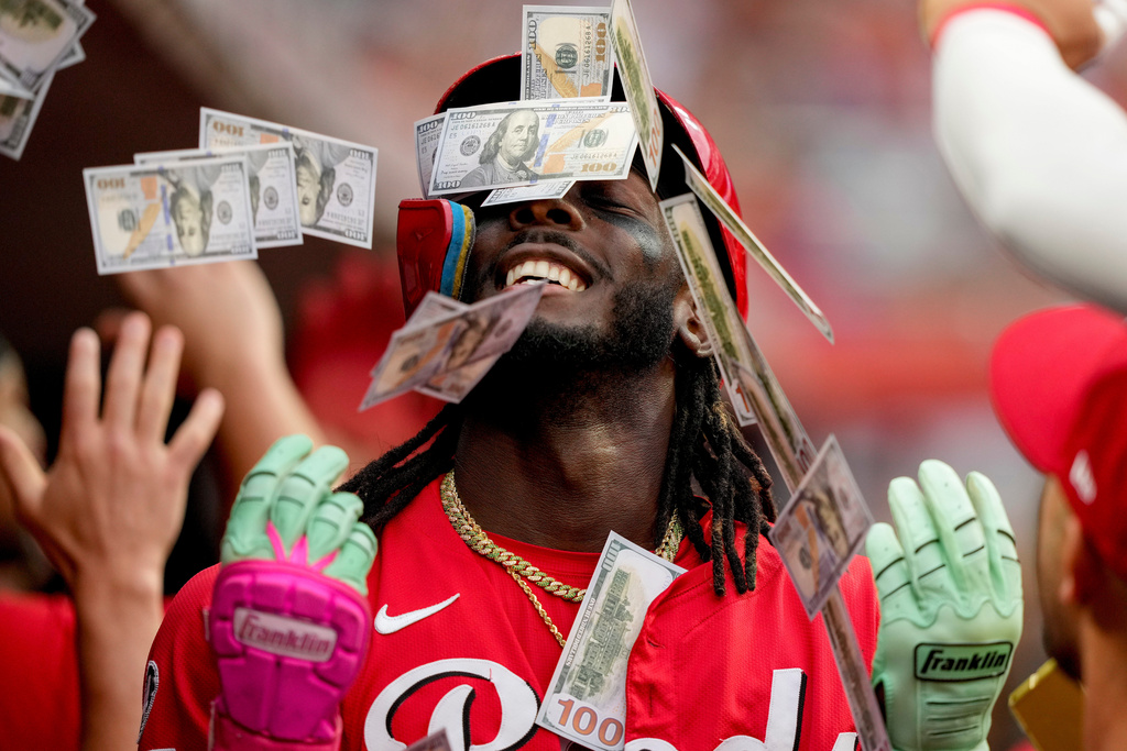 Teammates shower Cincinnati Reds' Elly De La Cruz with play money in the dugout after his two-run homer during the third inning of a baseball game against the Atlanta Braves, in Cincinnati, July 31, 2025. (AP Photo/Carolyn Kaster, File)