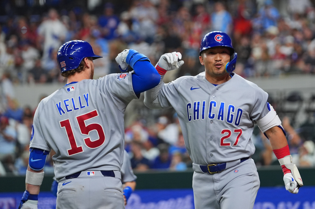 Chicago Cubs' Seiya Suzuki (27) is greeted by Carson Kelly (15) near home plate after hitting a two-run home run off Texas Rangers starting pitcher Kumar Rocker during the fourth inning of a baseball game Friday, May 8, 2026, in Arlington, Texas. (AP Photo/Julio Cortez)