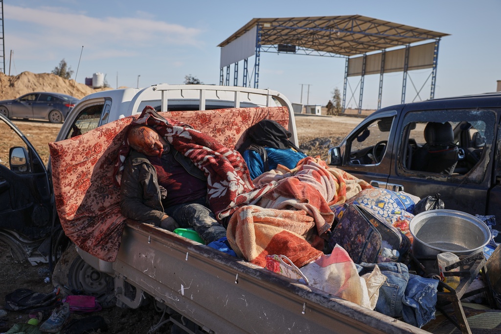 The bodies of civilians, believed to have been caught in crossfire between Syrian government forces and retreating Syrian Democratic Forces (SDF) troops, lies in the back of a pickup truck along a road between government-controlled Raqqa and SDF-controlled Hassakeh in northeastern Syria, Tuesday, Jan. 20, 2026. (AP Photo/Omar Albam)
