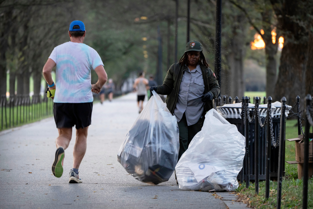A National Park Service employee empties trash containers along the National Mall on Wednesday, Oct. 1, 2025, in Washington. (AP Photo/Mark Schiefelbein)