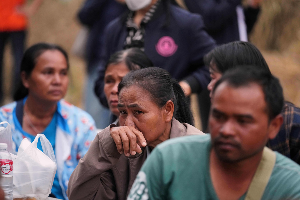 Relatives of victims and others react after a construction crane fell into a passenger train in Nakhon Ratchasima province, Thailand, Wednesday, Jan.14, 2026. (AP Photo/Sakchai Lalit))