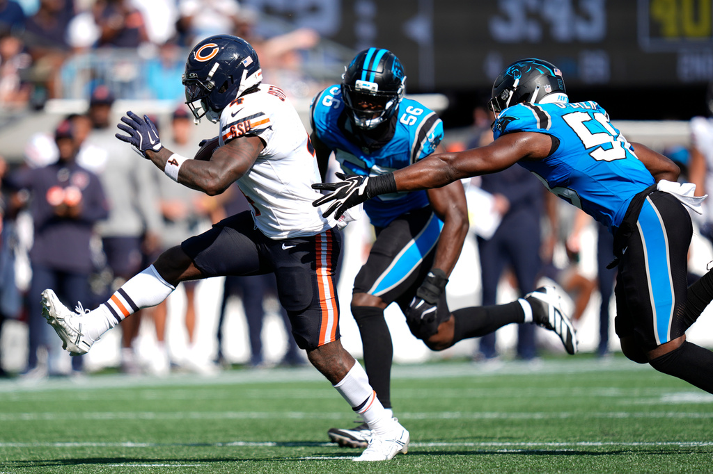 Chicago Bears running back D'Andre Swift (4) runs against Carolina Panthers linebacker Jeremiah Moon (56) and inside linebacker Bobby Okereke (58) to score a touchdown during the second half of an NFL football game, Sunday, Sept. 13, 2026, in Charlotte, N.C. (AP Photo/Erik Verduzco)