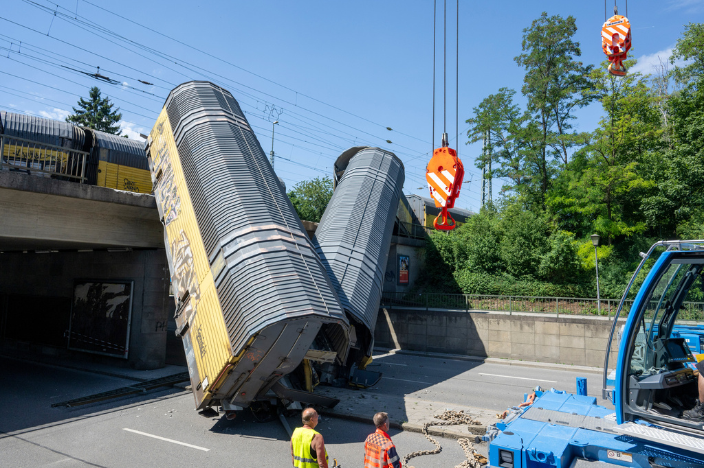 Two cars of a freight train are lying on a road after falling off a bridge in Munich, Germany, Saturday, June 20, 2026. (Stefan Puchner/dpa via AP)