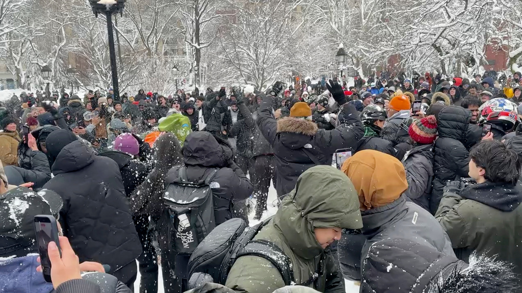 In this photo taken from video, people throw and duck snowballs during a snowball fight at Washington Square Park, Monday, February. 23, 2026 in New York. (AP Photo/David R. Martin)
