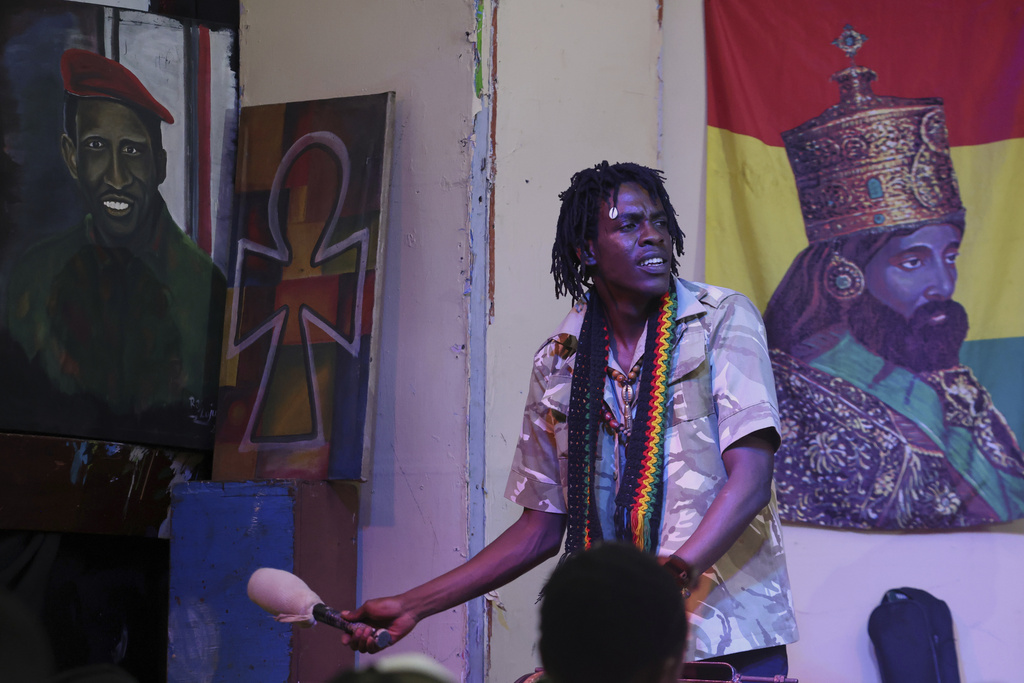 Members of the Rastafarian community play drums as others chant and sing during a celebration to mark 133 years since the birth of Haile Selassie I at the Kenya National Theatre in Nairobi, Kenya, Wednesday, July 23, 2025. (AP Photo/Andrew Kasuku)
